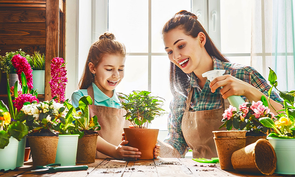 Pessoa cuidando de plantas com sua filha para ter renda extra